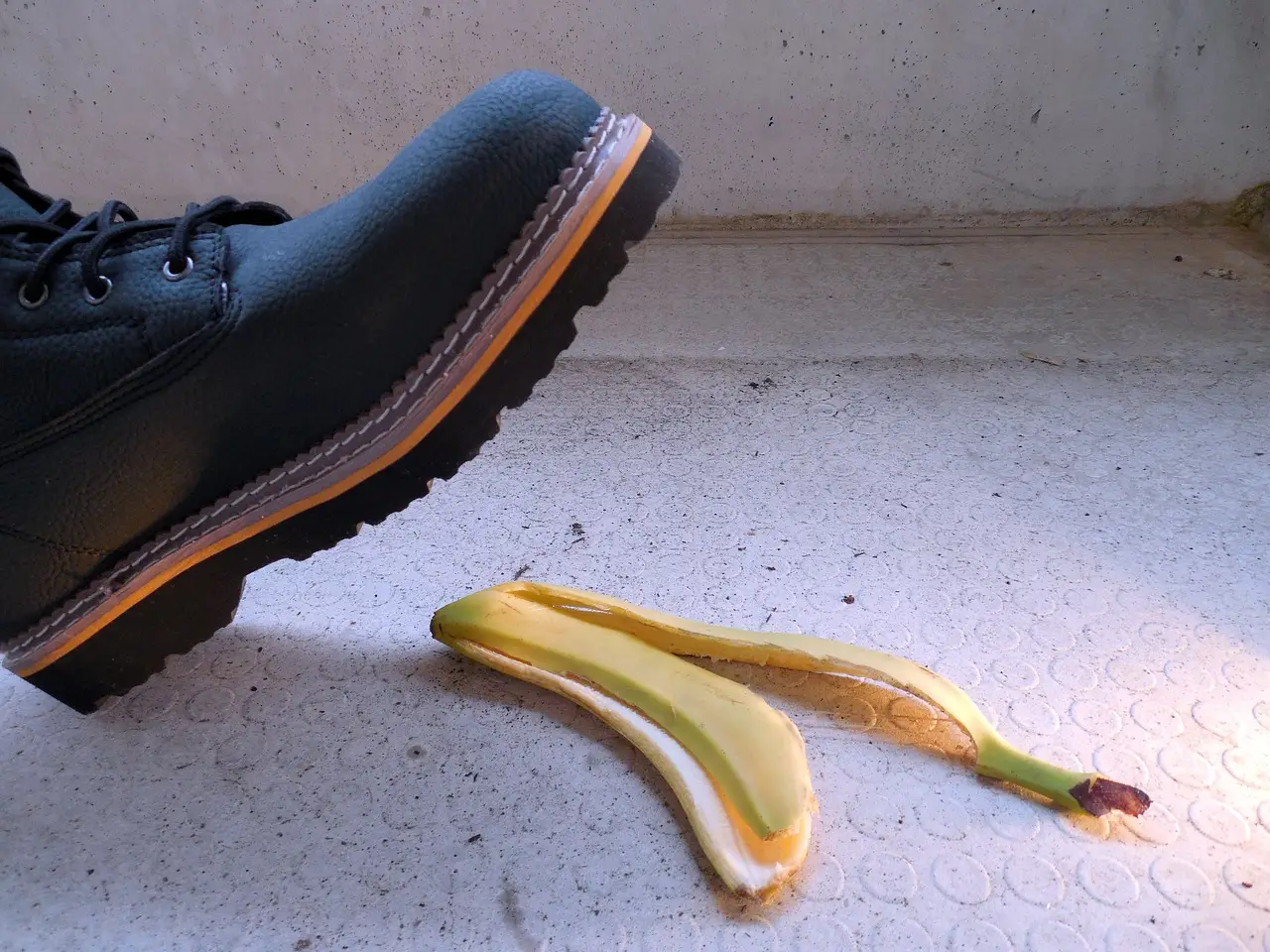 Boot about to step on a banana peel, illustrating potential injury risk or slip hazard